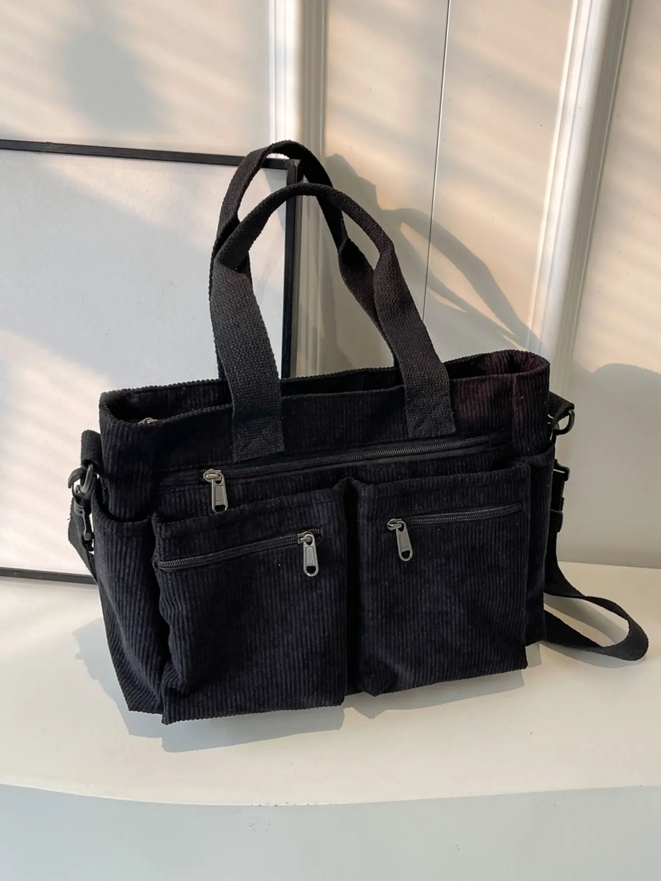 Niche design fashion canvas tote bag, can be carried by hand or worn crossbody with a wide adjustable shoulder strap, multiple pockets for layered storage, large capacity, practical and durable tote bag for students, work, or travel.