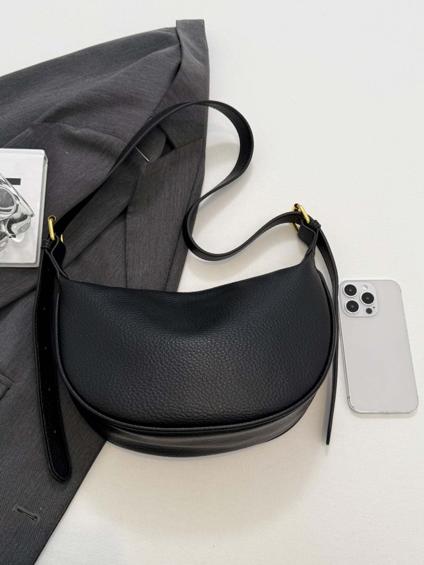 Black simple and fashionable lychee pattern crescent bag, niche pleated bag body, adjustable wide shoulder strap crossbody bag, metal buckle decoration, lightweight daily commuter bag, suitable for shopping, dating, etc.