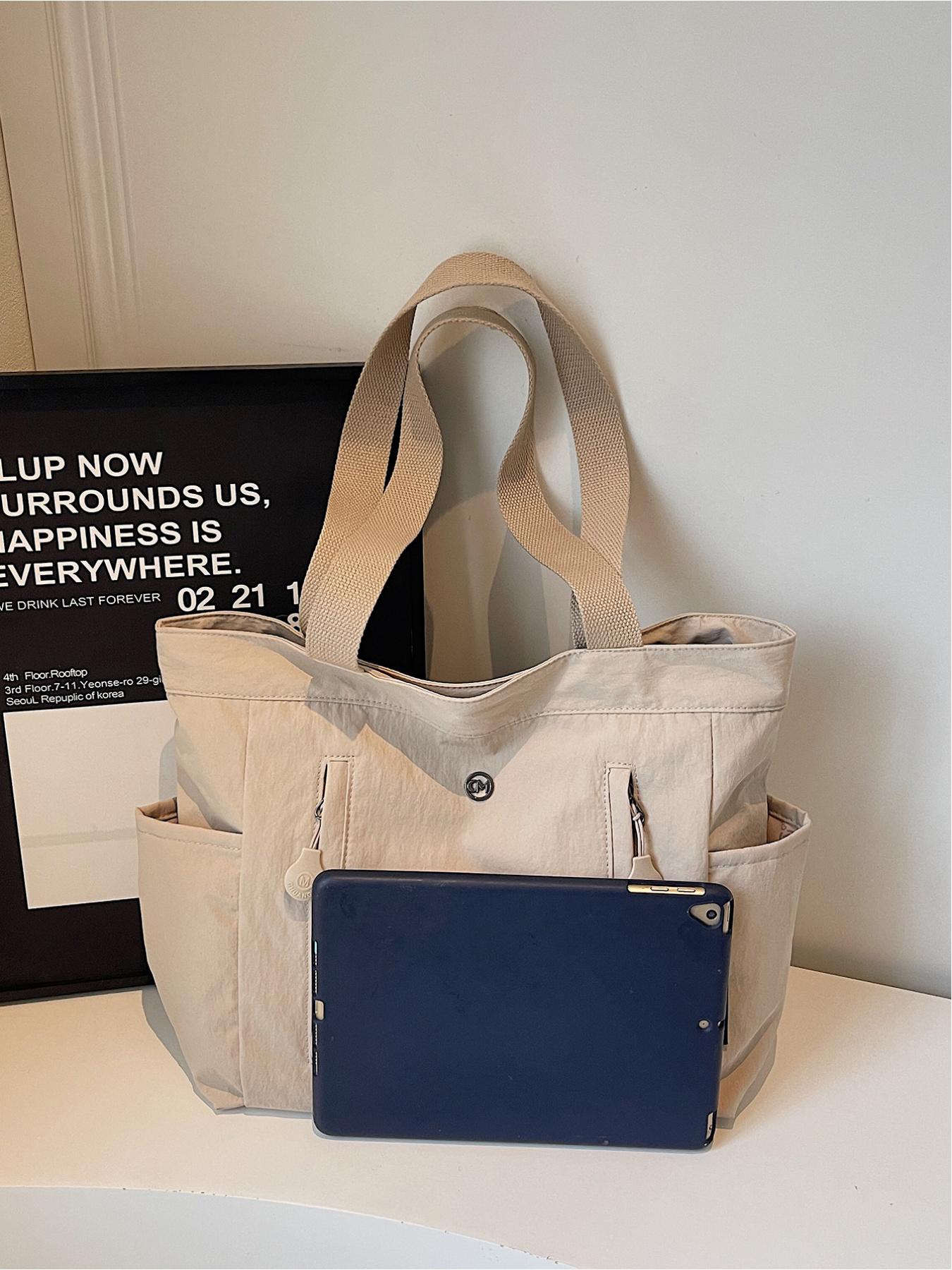 The large capacity soft commuter tote bag, is lightweight, spacious, suitable for daily use. It is a neutral waterproof nylon shoulder bag with a spacious interior suitable for 15 inch laptops, multiple side pockets, and a comfortable adjustab
