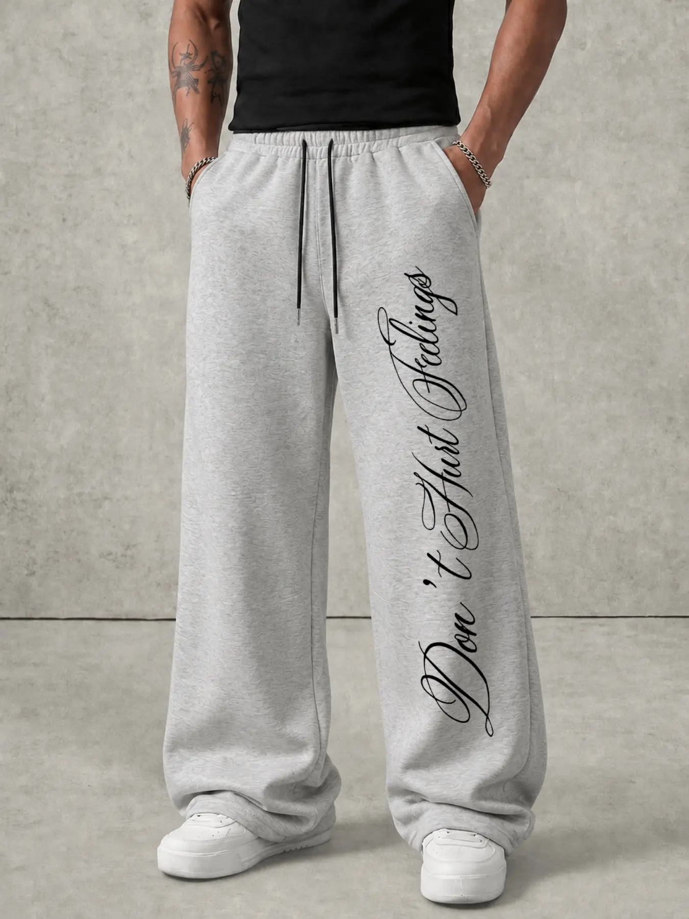 Light Heather Grey Men Hip‑Hop Streetwear Track Pants, Relaxed Straight‑Leg Sweatpants With Vertical Cursive Script Graphic on Side Leg, Durable Breathable Drawstring Waist Trousers With Side Pockets for Urban Going‑Out Skate Daily Street Outfit