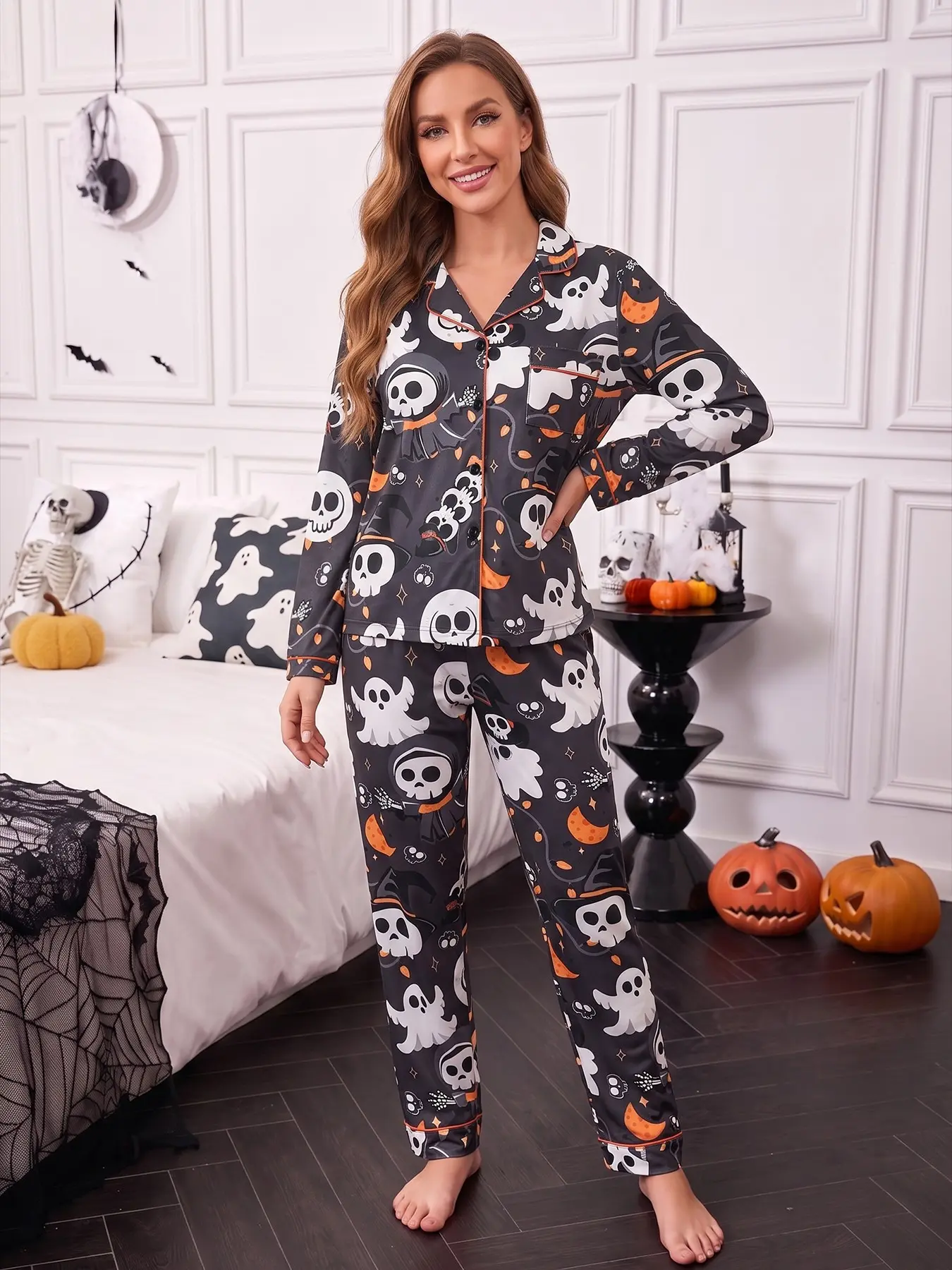 Women's 2-piece pajama set, black base printed with Halloween skeletons, grim reaper, ghosts, moons, stars & skeleton hands, cool Halloween style. Orange piping lapel top with pocket, soft elastic long pants, all-season casual women loungewear Nightwear