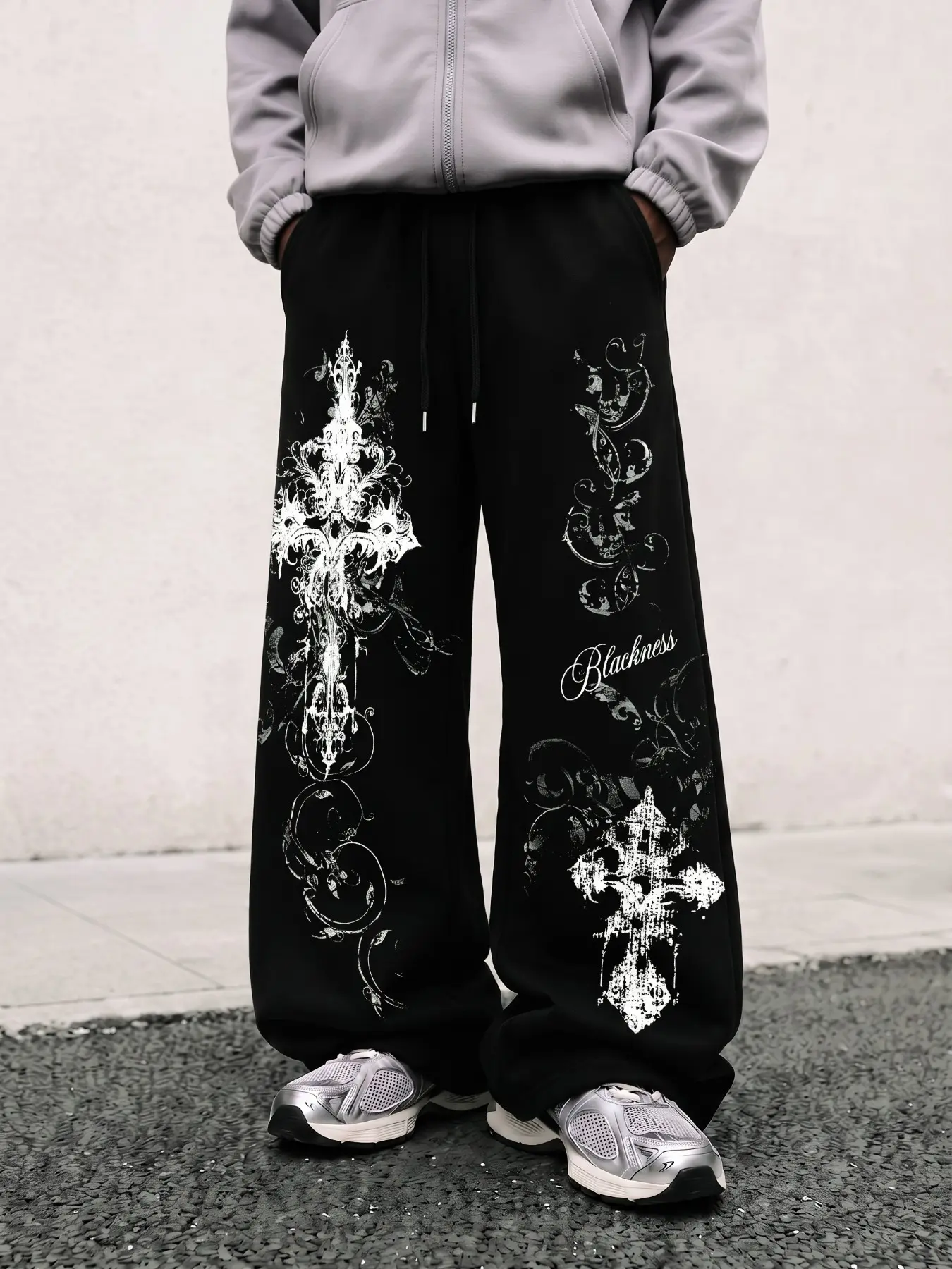 Black wide-leg sweatpants with gothic-style graphic prints, loose fit, Oversized for a hip-hop streetwear vibe, elastic drawstring waistband, soft and casual fabric. Perfect for street photos, skateboarding, or weekend outings.
