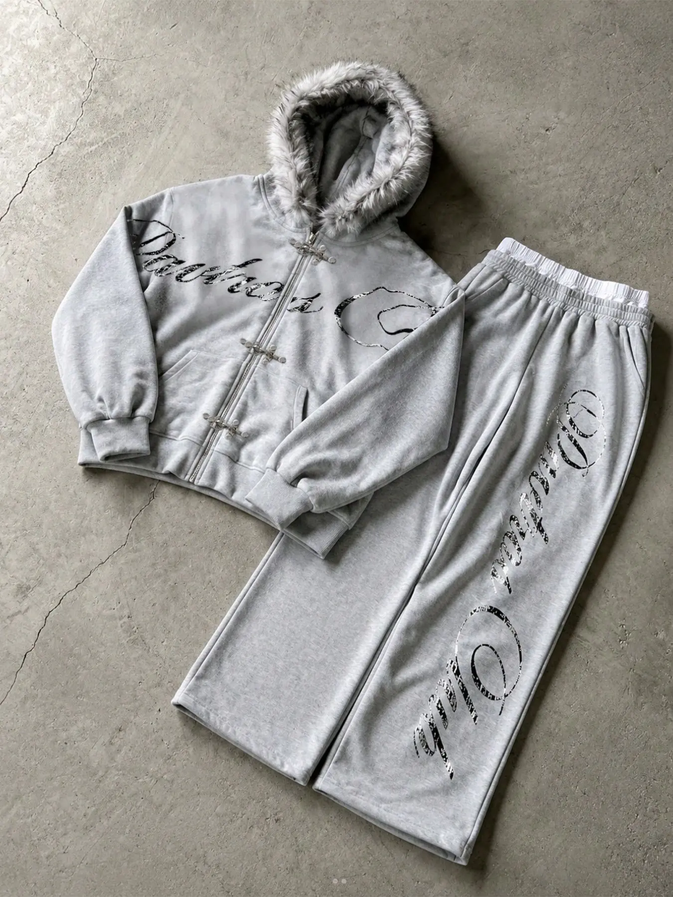 Men's gray two-piece tracksuit, faux-fur trim hooded zip-up jacket & wide-leg sweatpants, featuring buckle details and handwritten-style prints, soft fleece lining, a casual streetwear set for winter
