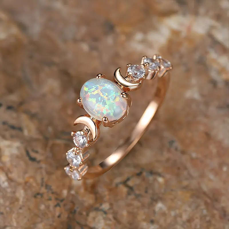 Chic and versatile champagne gold four-prong oval white Australian opal ring with crescent moon side accents.