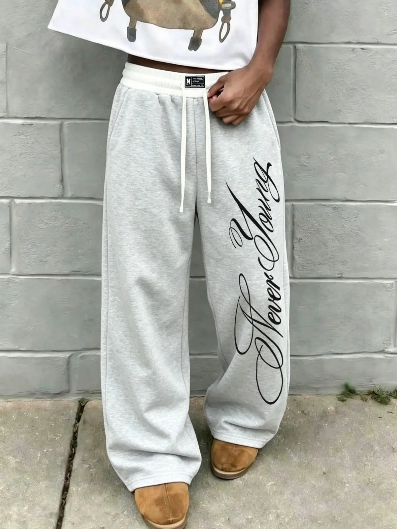 Men Unisex Heather Grey Wide Leg Sweatpants, Cursive Never Young Vertical Script Print Baggy Joggers, Elastic White Drawstring High Waist Soft Fleece Loose Fit Track Pants, Stretch Breathable Streetwear Trousers For Skate Dance College Campus Daily Casual