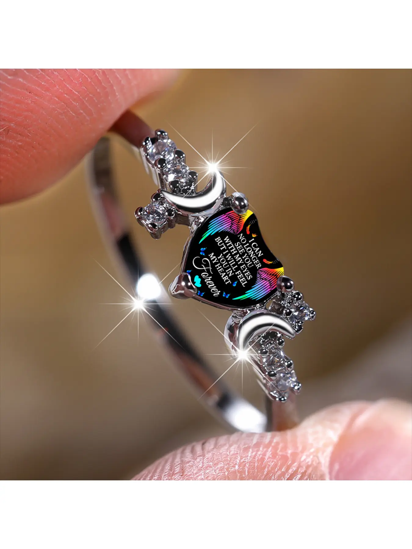 Rainbow wings, a crescent moon, a silver ring with broken diamonds, a heartfelt remembrance of loved ones, engraved with love, a small, emotional bond