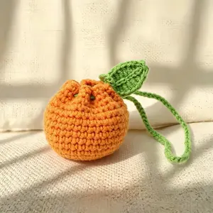 A small, hand-woven storage bag shaped like a mandarin orange. Doubling as a cute coin purse, it can be displayed on a bookshelf, desk, or side table—adding charm and utility to your space with its compact, minimalist design.
