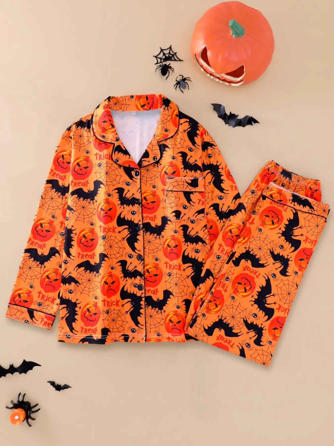 Women's 2-piece pajama set, orange base with Halloween jack-o'-lanterns, bats, spider webs & Trick or Treat print, fun classic spooky style. Black piping lapel top with pocket, soft elastic long pants, casual women loungewear