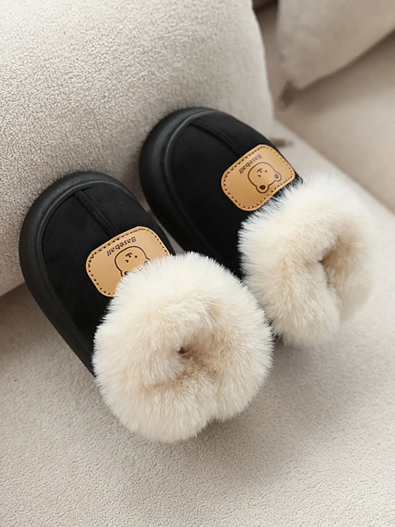 A pair of warm and furry indoor shoes suitable for children, decorated with cute little bears, and a pair of snow boots for one foot