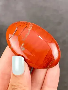 1pc red jasper palm stone, a smooth jade crystal pocket gemstone, is ideal for Christmas, Thanksgiving, and table decorations. It features a polished surface with a striped pattern.