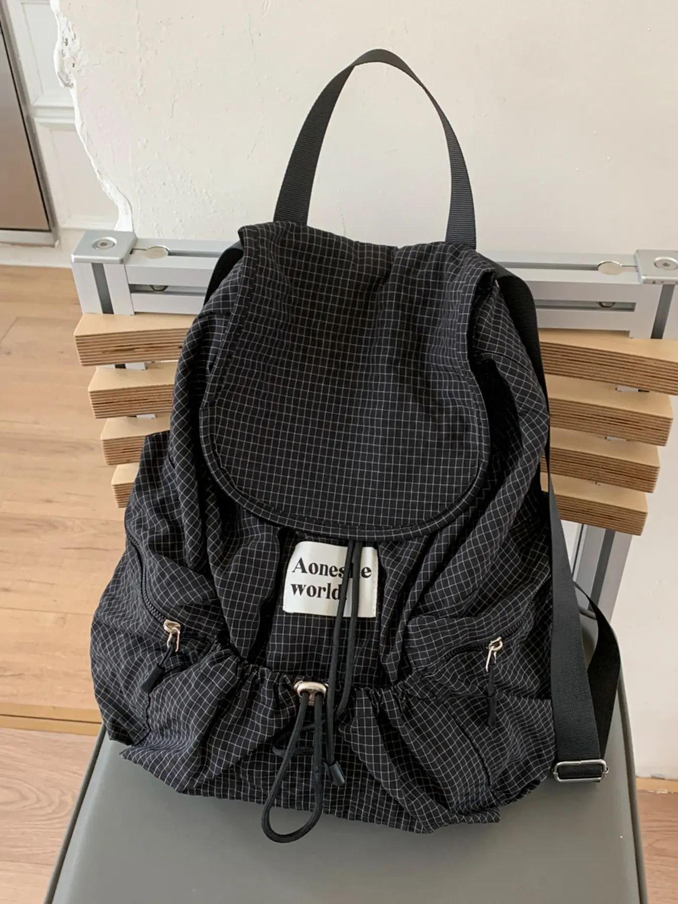 Commuting new leisure relaxed pleated plaid flip backpack, multiple drawstring pockets design, large capacity simple style fashionable high-quality backpack, can accommodate books, documents, tablets.