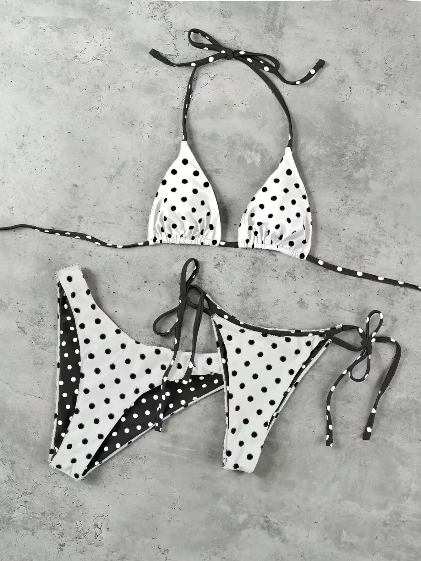 Black and white polka dot three-piece bikini set with two pairs of bottoms for the beach