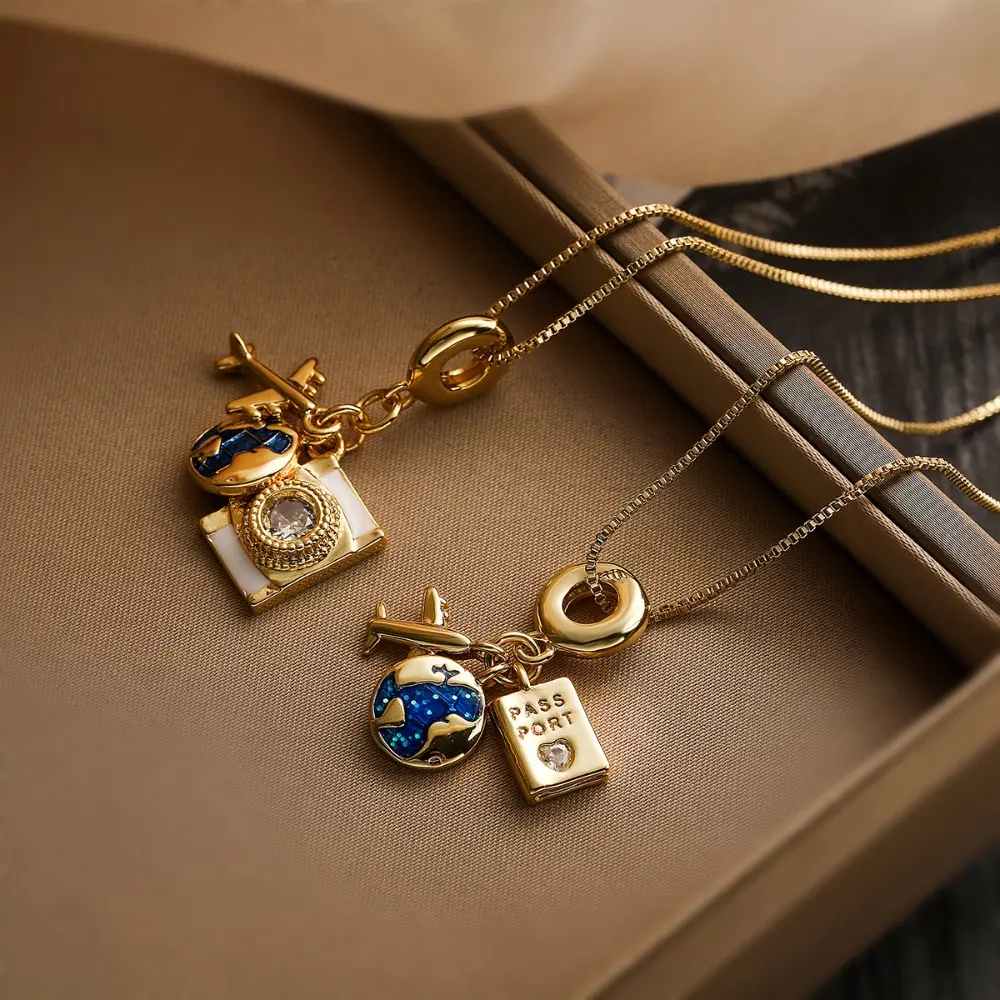 Exquisite Travel-Themed Pendant Necklace (Gold-tone): Features charms shaped like a camera, airplane, blue enamel globe, and passport, all set with sparkling crystals.