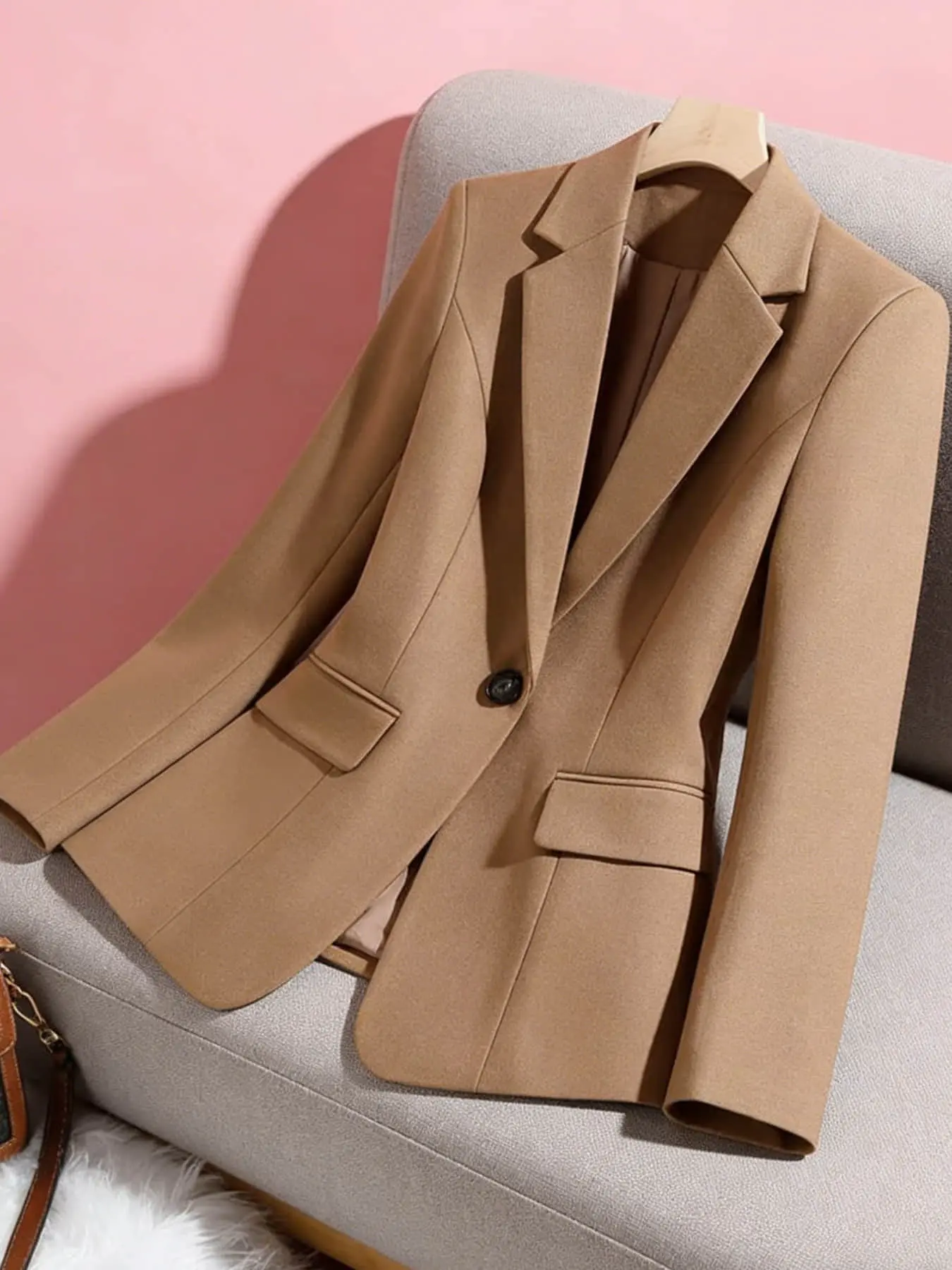A women's minimalist commuting style camel colored suit jacket, Fitted blazer jacket, with a button closure, slim fitting and versatile, with a professional feel. Suitable for spring and autumn, interviews